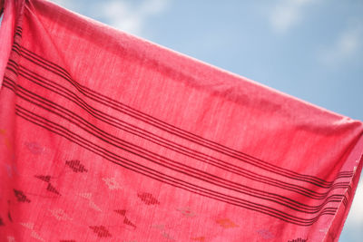 Low angle view of pink umbrella against sky