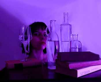 Portrait of young woman in book on table