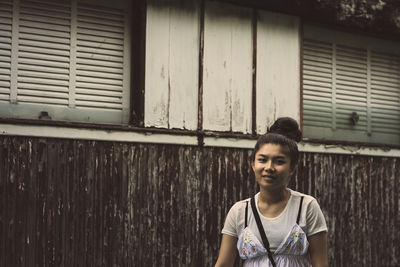 Portrait of teenage girl standing against building