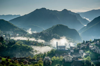 Aerial view of townscape and mountains against sky