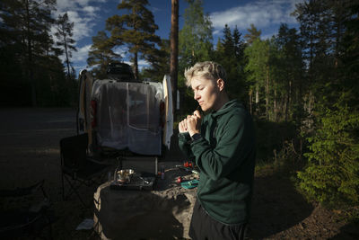 Woman camping in forest in van