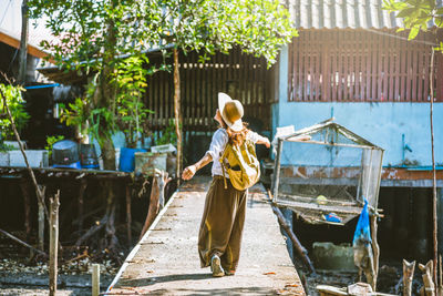 Rear view of woman standing by building