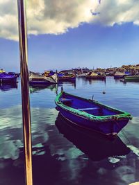 Boats moored in river against sky