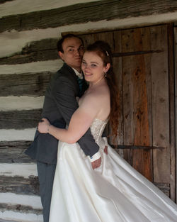 Happy couple standing against wall