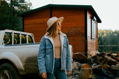 Midsection of woman standing by car