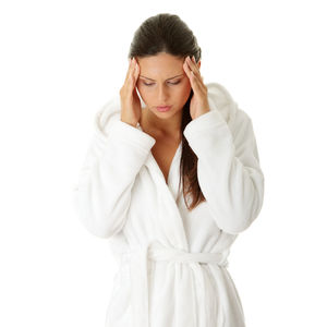 Young woman looking away while standing against white background