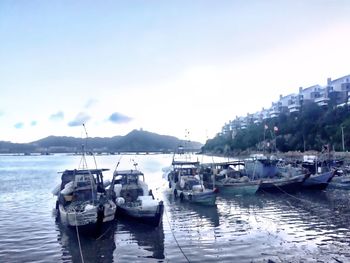 Boats moored in sea against sky