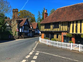 Road by buildings against sky in city
