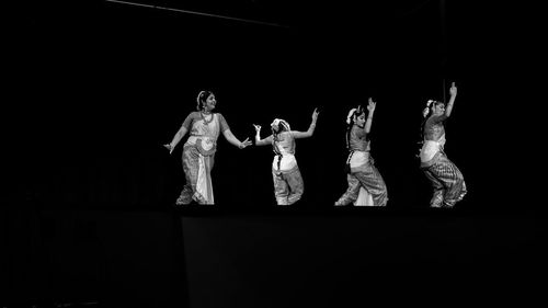 Group of people standing against black background