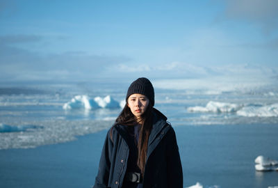 Mid adult man standing against sea during winter