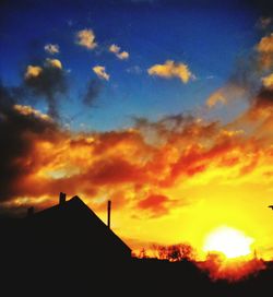 Low angle view of silhouette trees against sunset sky