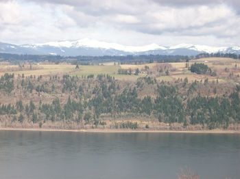 Scenic view of lake and mountains against cloudy sky