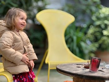 Smiling girl looking away while standing in yard