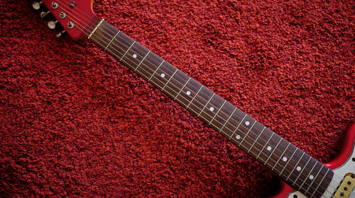 High angle view of guitar on carpet