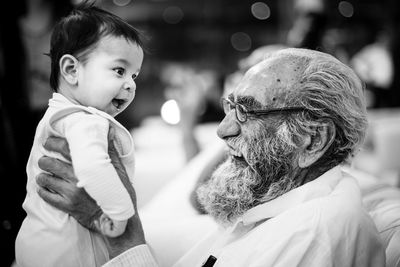 Side view of grandfather plying with son