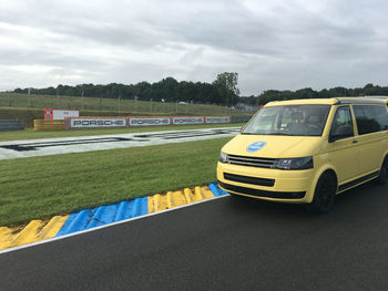 Yellow car on road against sky