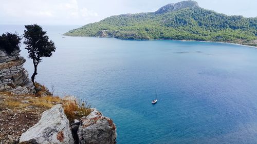 Scenic view of calm sea against mountain range