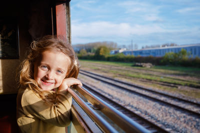 Portrait of young woman standing on railroad track