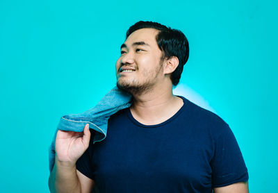 Portrait of young man against blue background