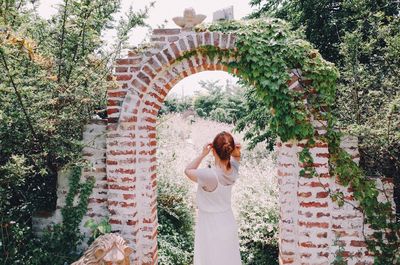 Rear view of woman standing amidst archway