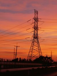 Low angle view of silhouette electricity pylon against romantic sky at sunset