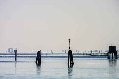 People on beach against clear sky