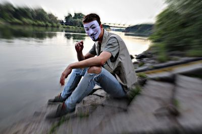 Side view of young man sitting in water