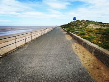 Road leading towards sea against sky