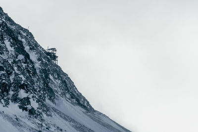 Low angle view of snowcapped mountain against clear sky