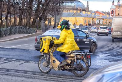 Rear view of man riding motorcycle on road in winter