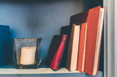 Close-up of books on table against wall