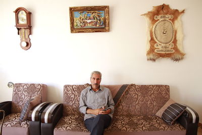 Portrait of man sitting on sofa at home