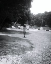 Rear view of boy walking on road