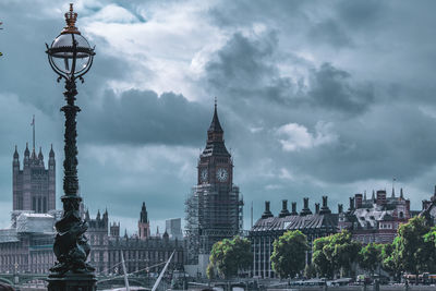 Buildings in city against cloudy sky