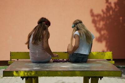 Rear view of mother with daughter on table