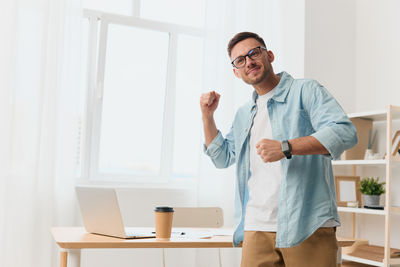 Portrait of young man standing in office