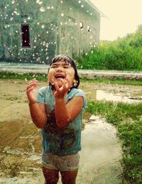 Portrait of happy boy in puddle