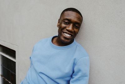 Portrait of smiling man against wall