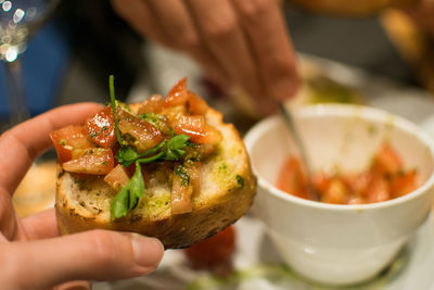 Close-up of hand holding food in plate