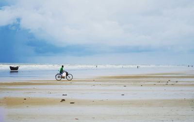 A man cycling on a sea beach