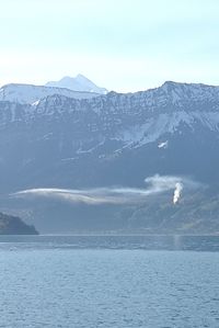 Scenic view of snowcapped mountains by sea against sky