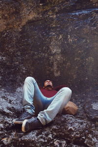 Full length of man relaxing on rock