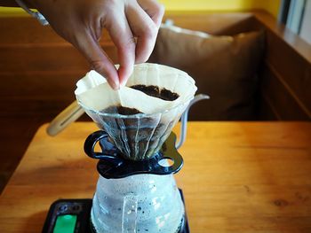 Close-up of woman hand holding drink on table