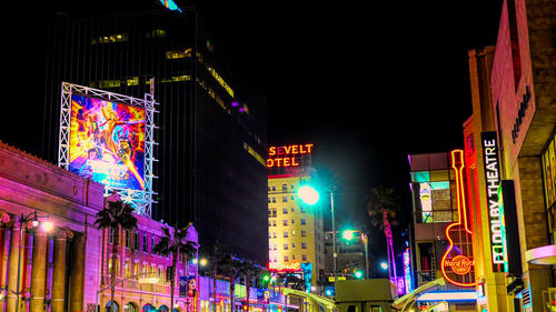 Low angle view of illuminated buildings in city at night