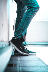 Low section of man standing on tiled floor