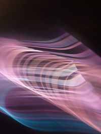 Close-up of illuminated light bulb against black background