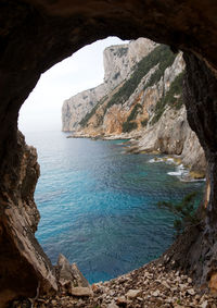Rock formations by sea against sky