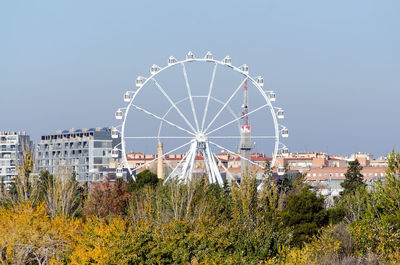 Ferris wheel by buildings against sky