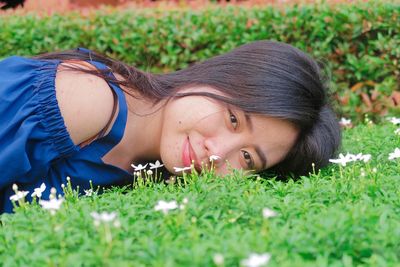 Portrait of woman lying on field