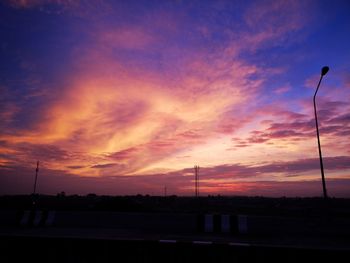 Scenic view of silhouette street against sky at sunset